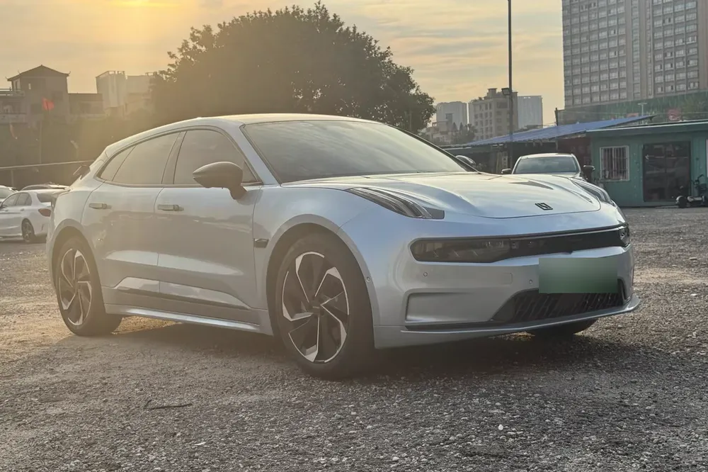 A silver Zeekr 001 photographed at sunset in the yard where it is held in Foshan